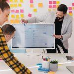 Man Standing Behind Flat Screen Computer Monitor